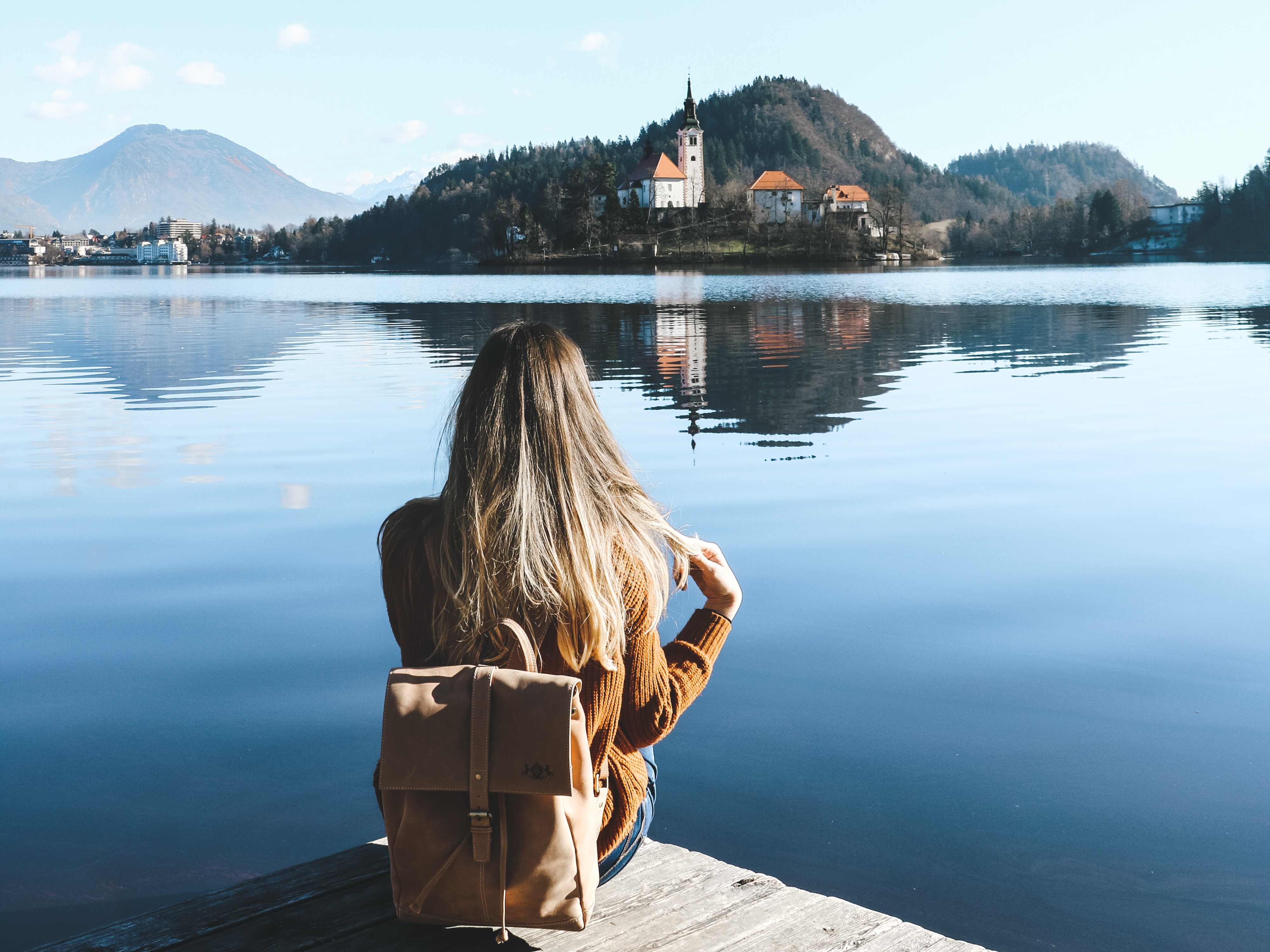 Moodbild Model sitzt am See mit Rucksack Leder Damen